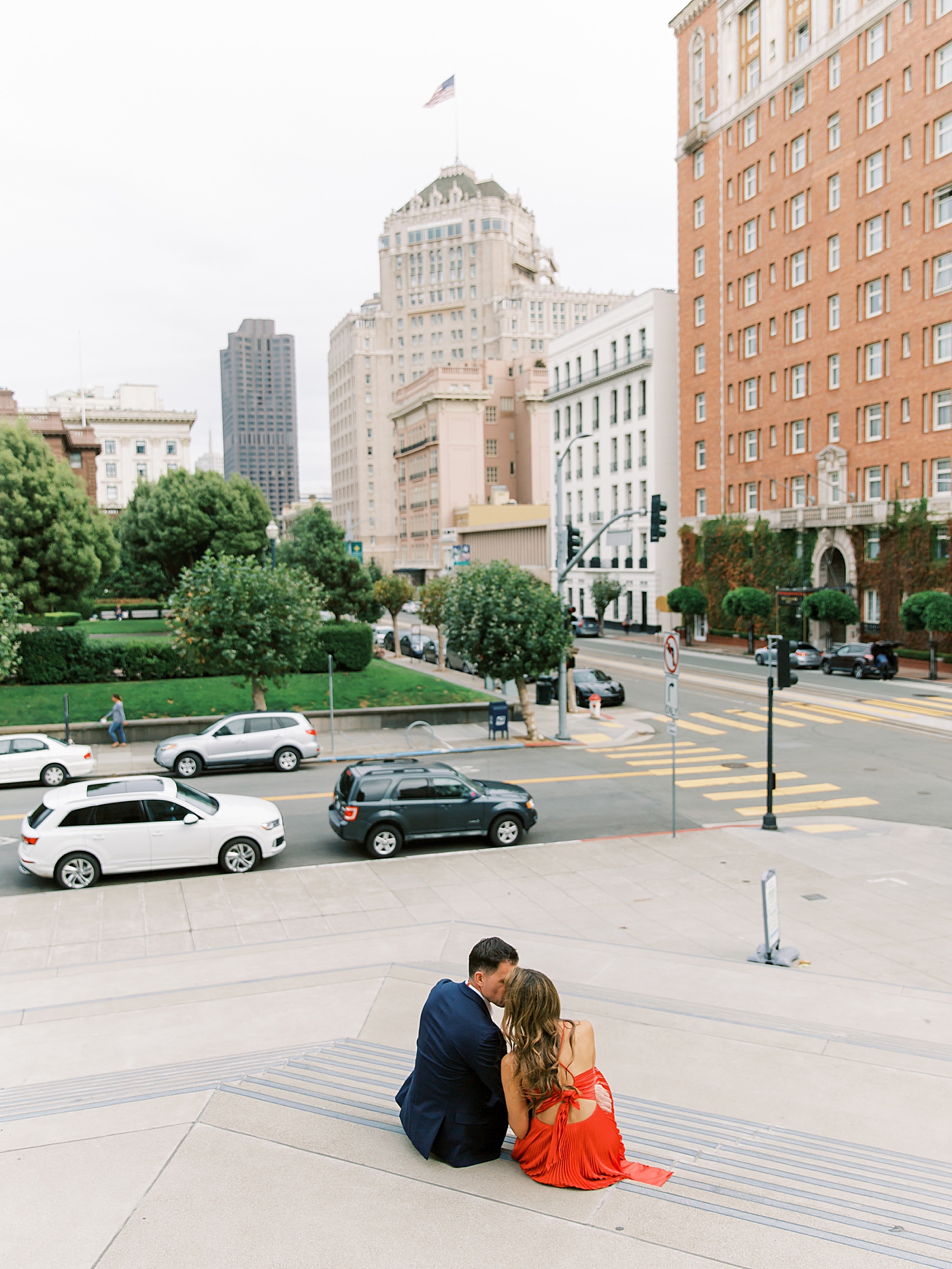 Couple in red and black sitting on the steps of the Fairmont | Photo by Diane Sotero