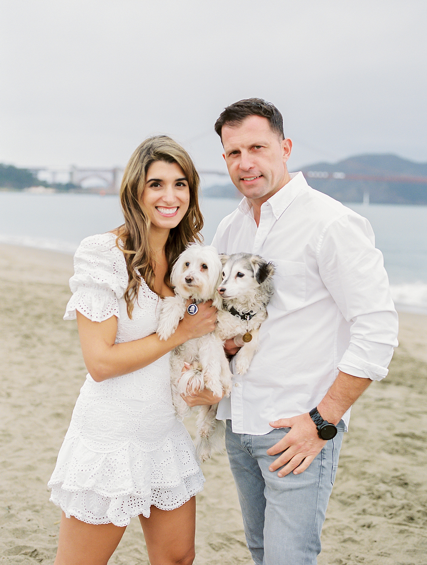Couple smiling while holding their dogs during their San Francisco engagement session | Photo by Diane Sotero