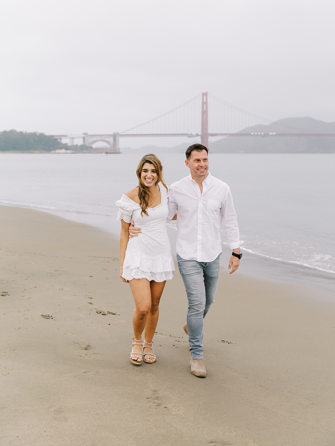 Couple laughing on the beach during their San Francisco engagement session | Photo by Diane Sotero