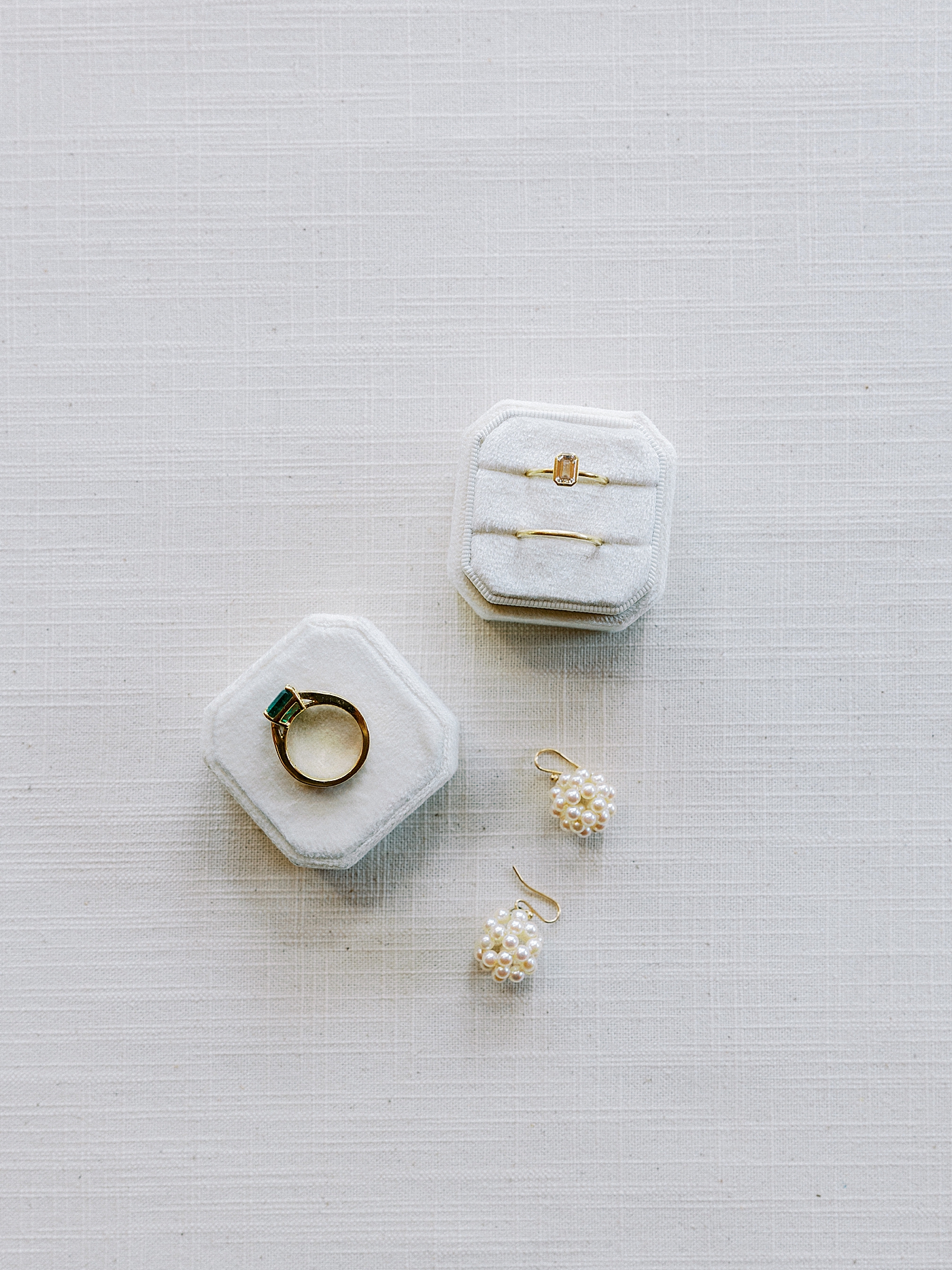 Bride's rings and earrings styled on a white surface | Photo by Diane Sotero Photography