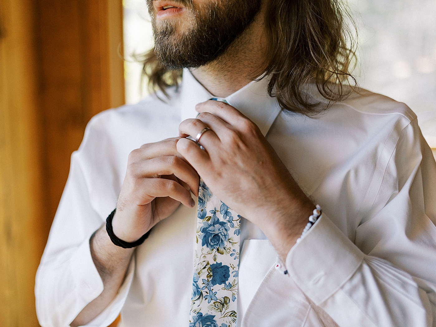 Groom putting on his tie before his North Carolina Wedding | Photo by Diane Sotero Photography