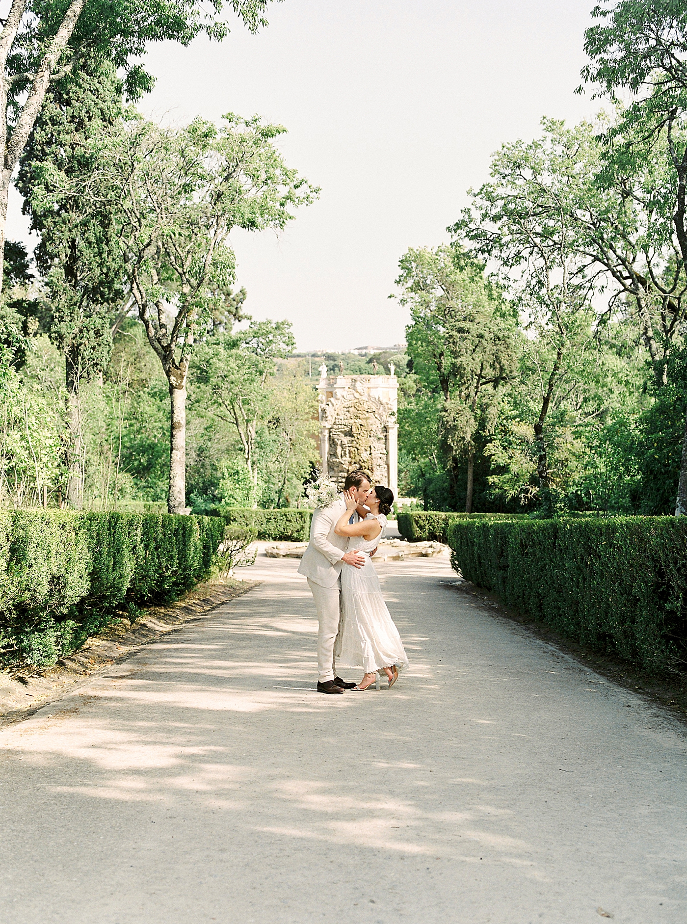 Couple kissing on a path outside Palacio de Queluz | Photo by Diane Sotero 