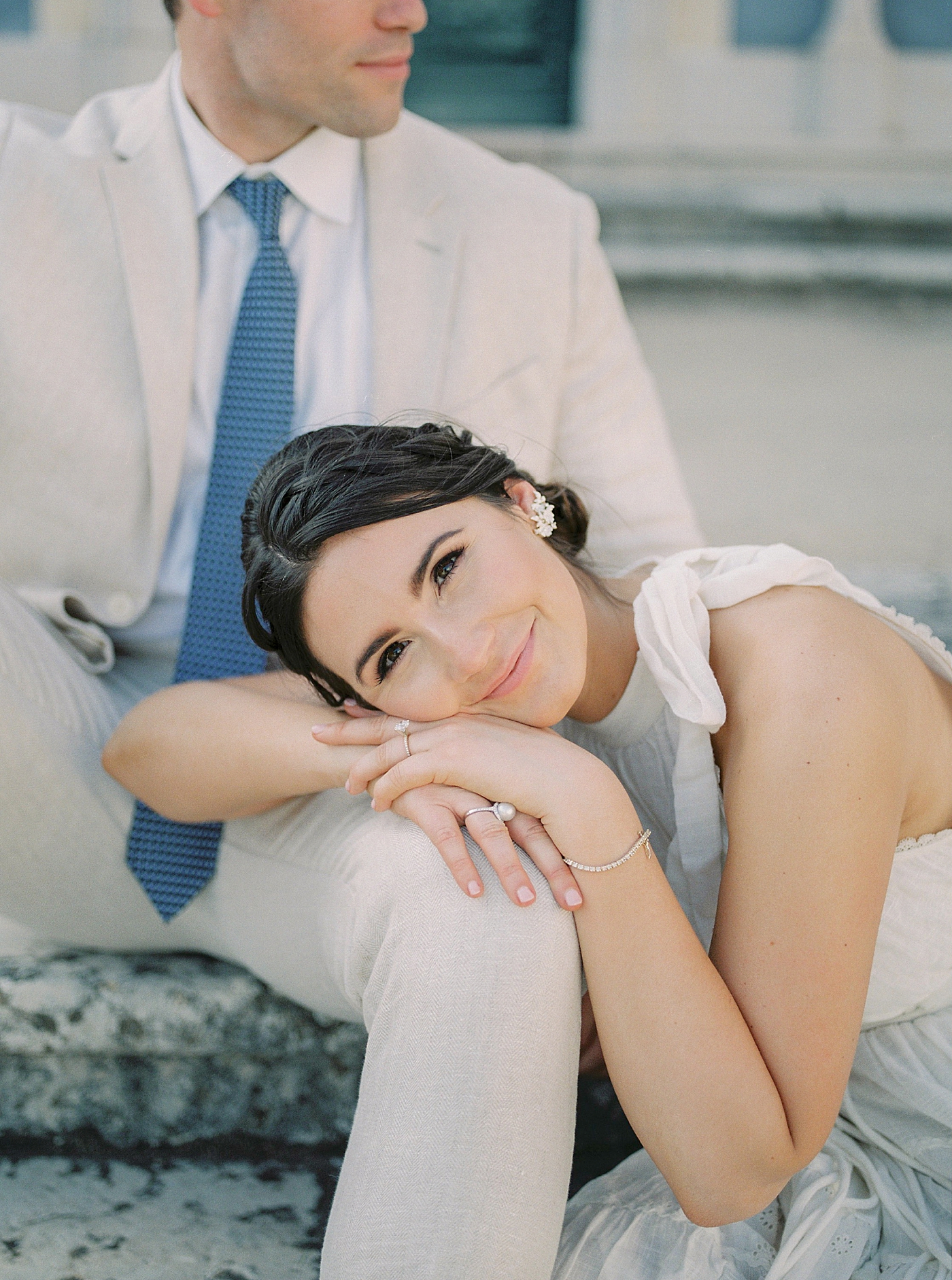 Woman with dark hair leaning on her fiancé's knee | Photo by Diane Sotero 