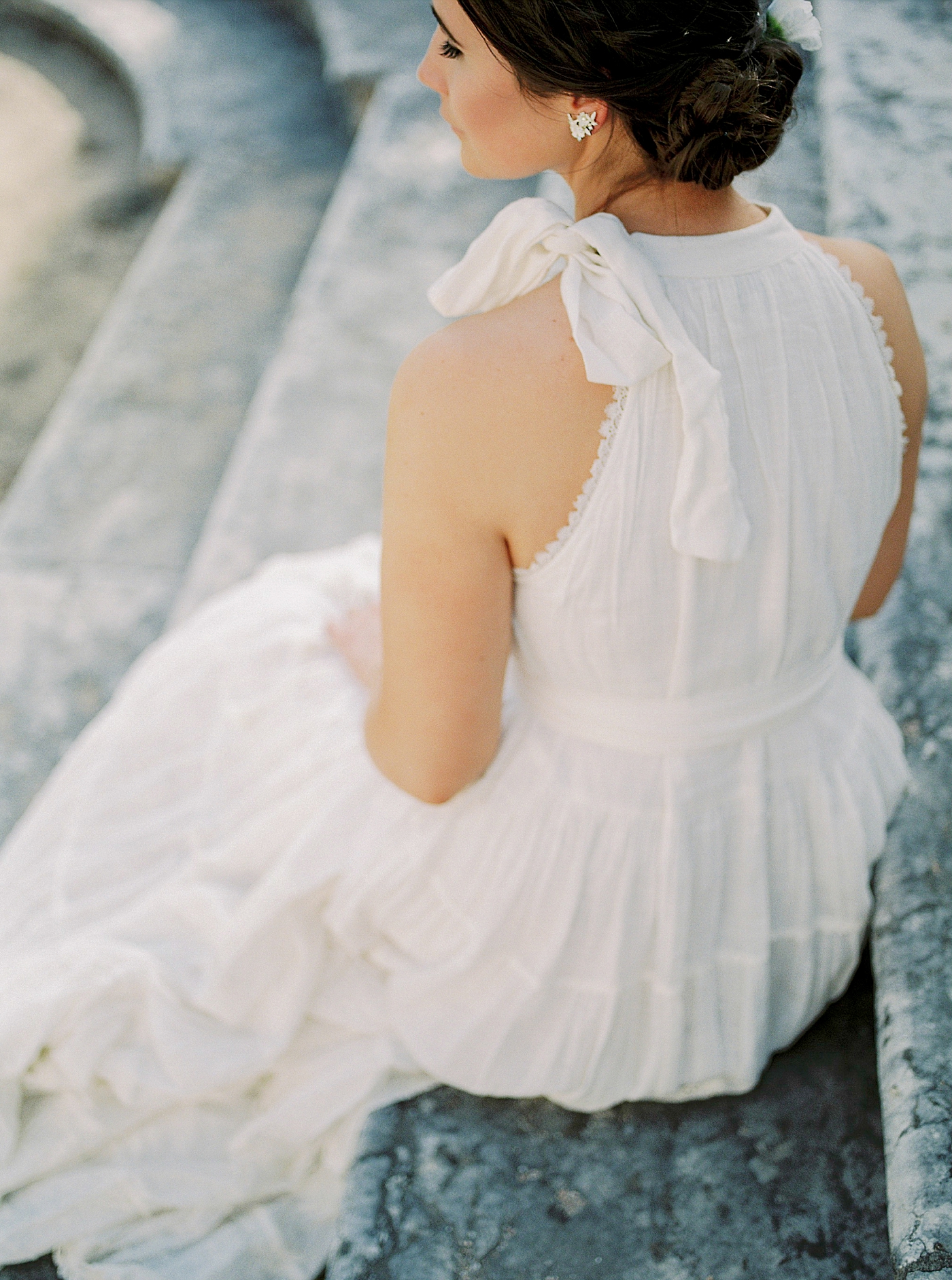 Detail of woman in a white dress sitting on a step in Lisbon | Photo by Diane Sotero Photography