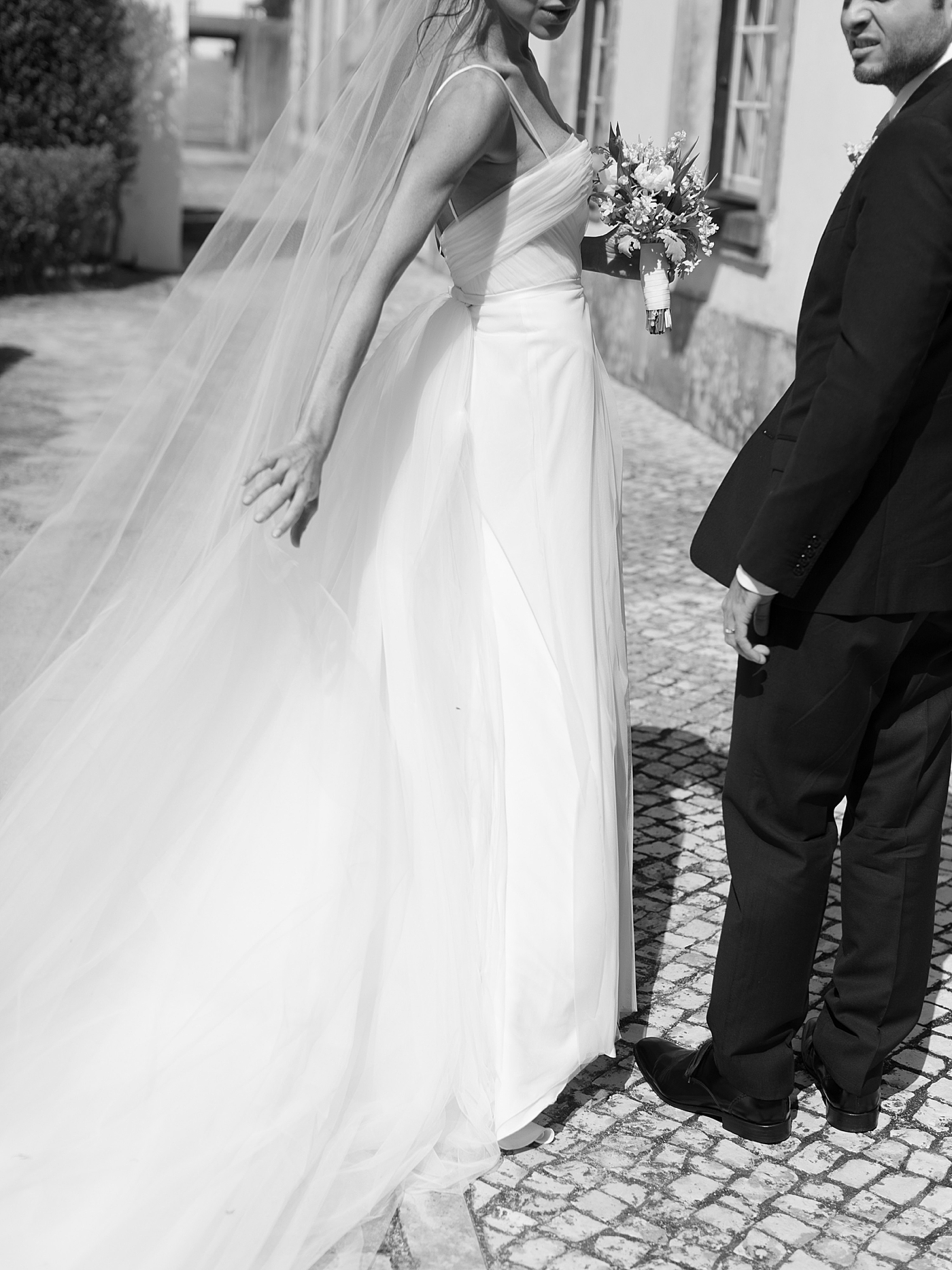 Black and white image of bride adjusting her dress | Image by Diane Sotero Photography