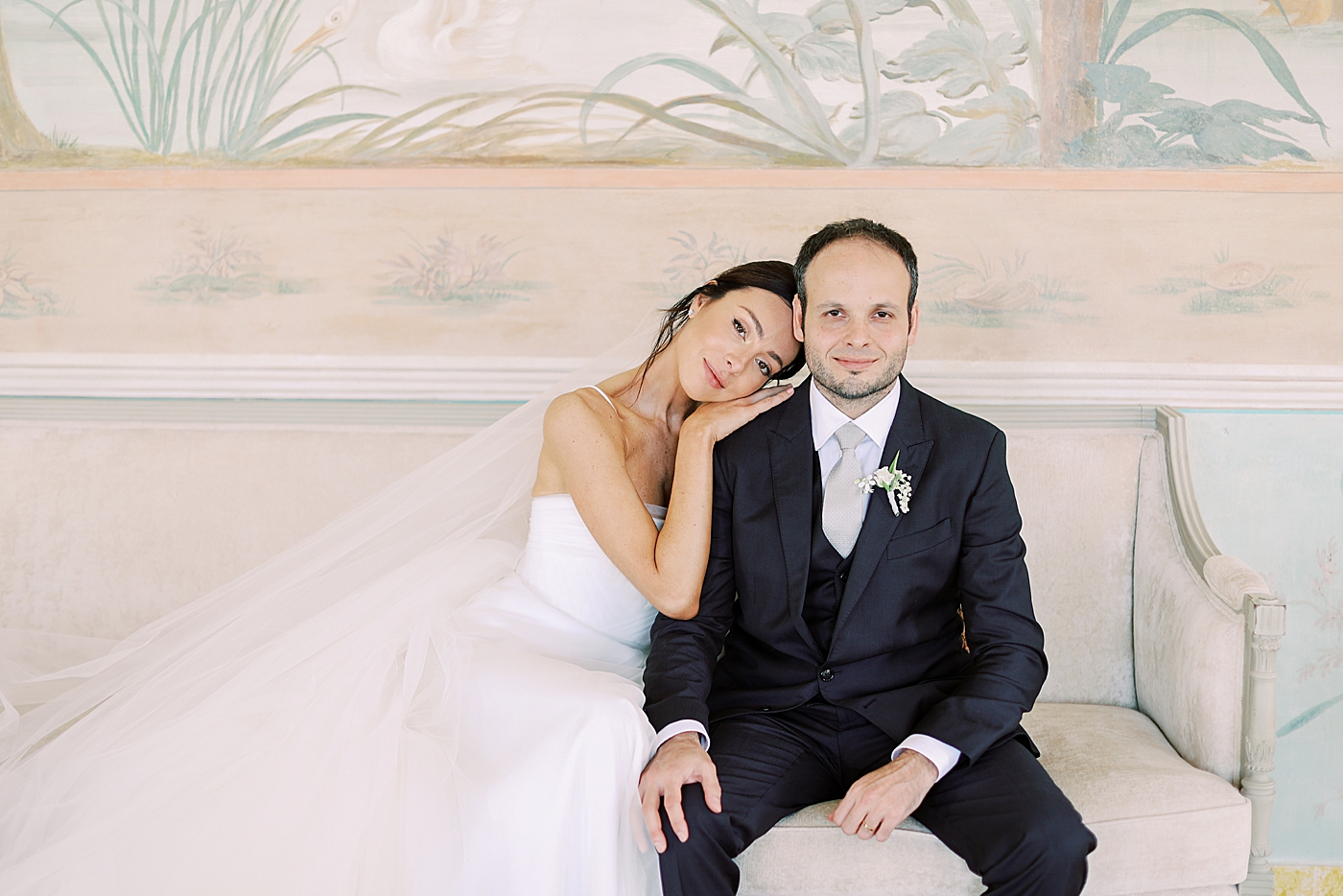 Bride and groom sitting on a sofa | Image by Diane Sotero Photography