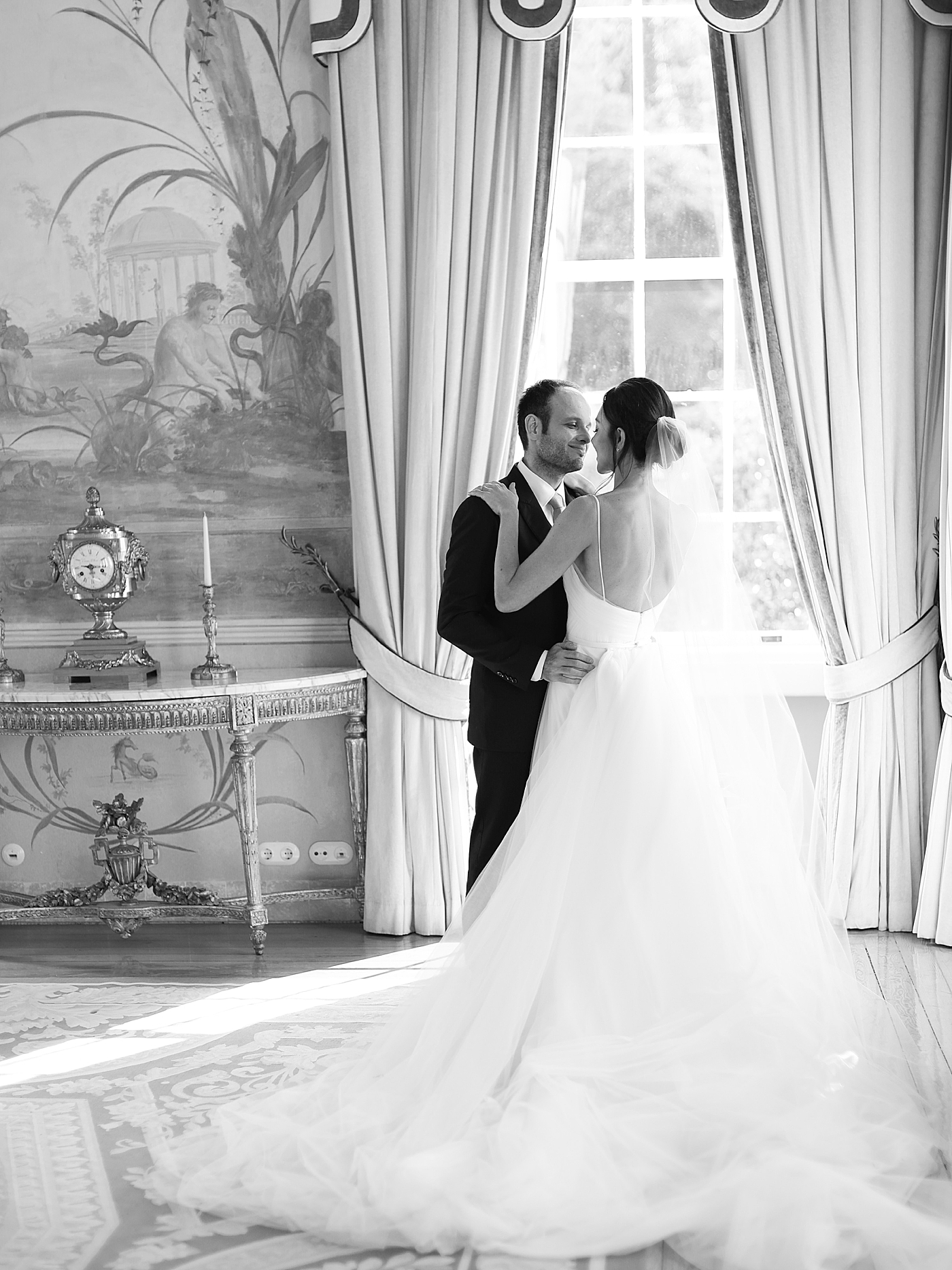 Black and white image of bride and groom near a window | Image by Diane Sotero Photography