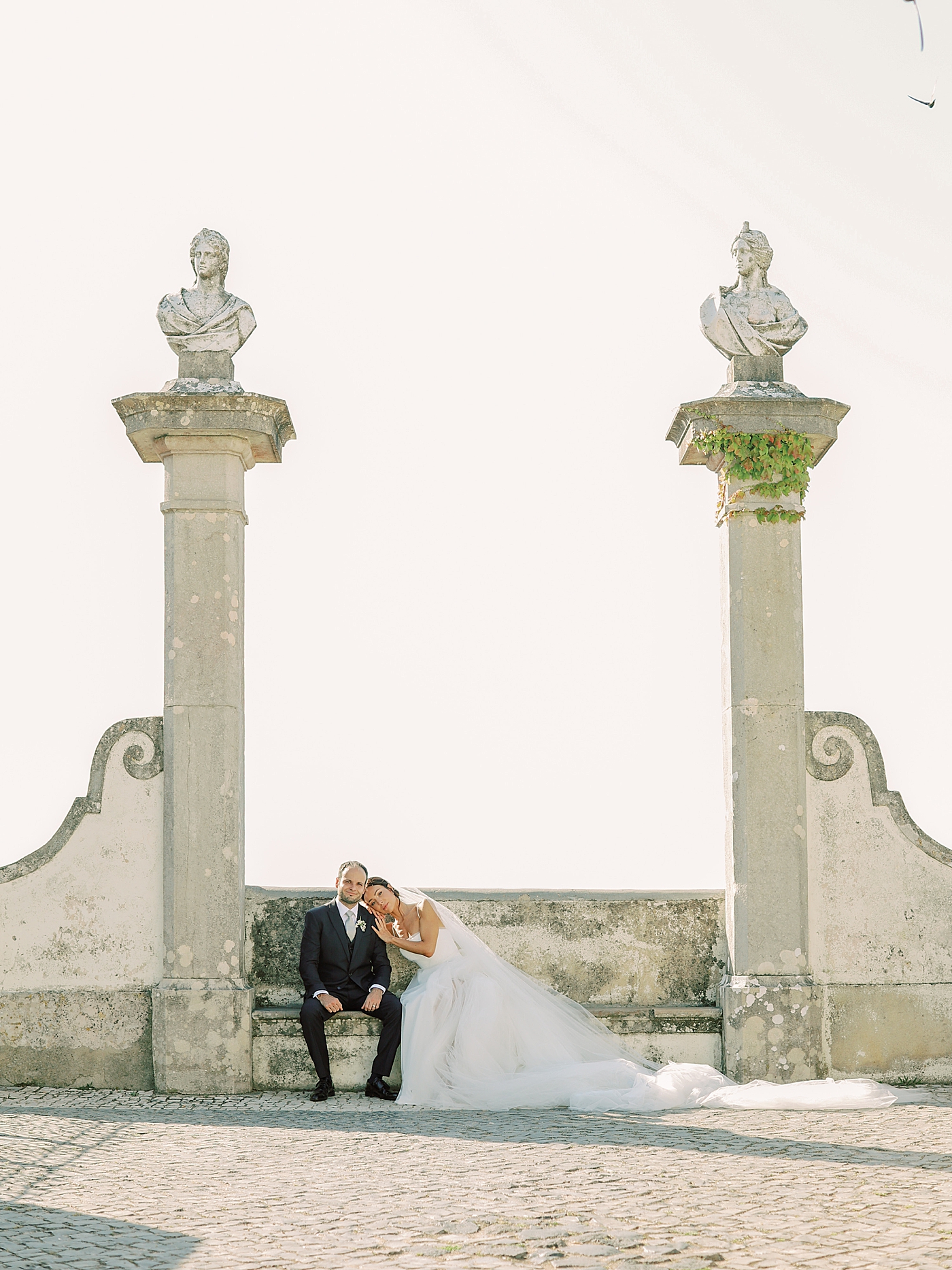 Bride and groom sitting near a wall | Image by Diane Sotero Photography
