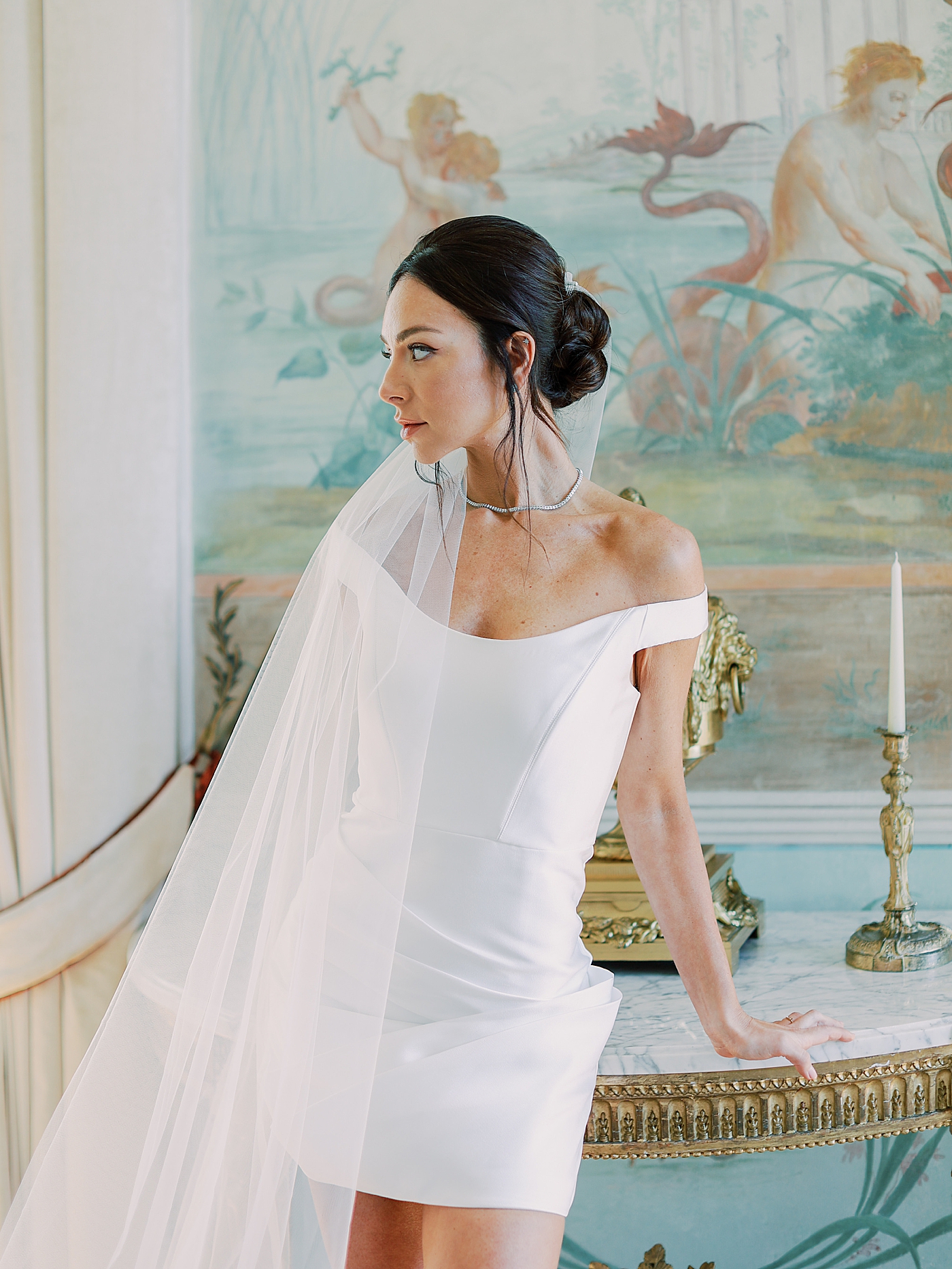 Bride in a reception dress and veil leaning on a table | Image by Diane Sotero Photography