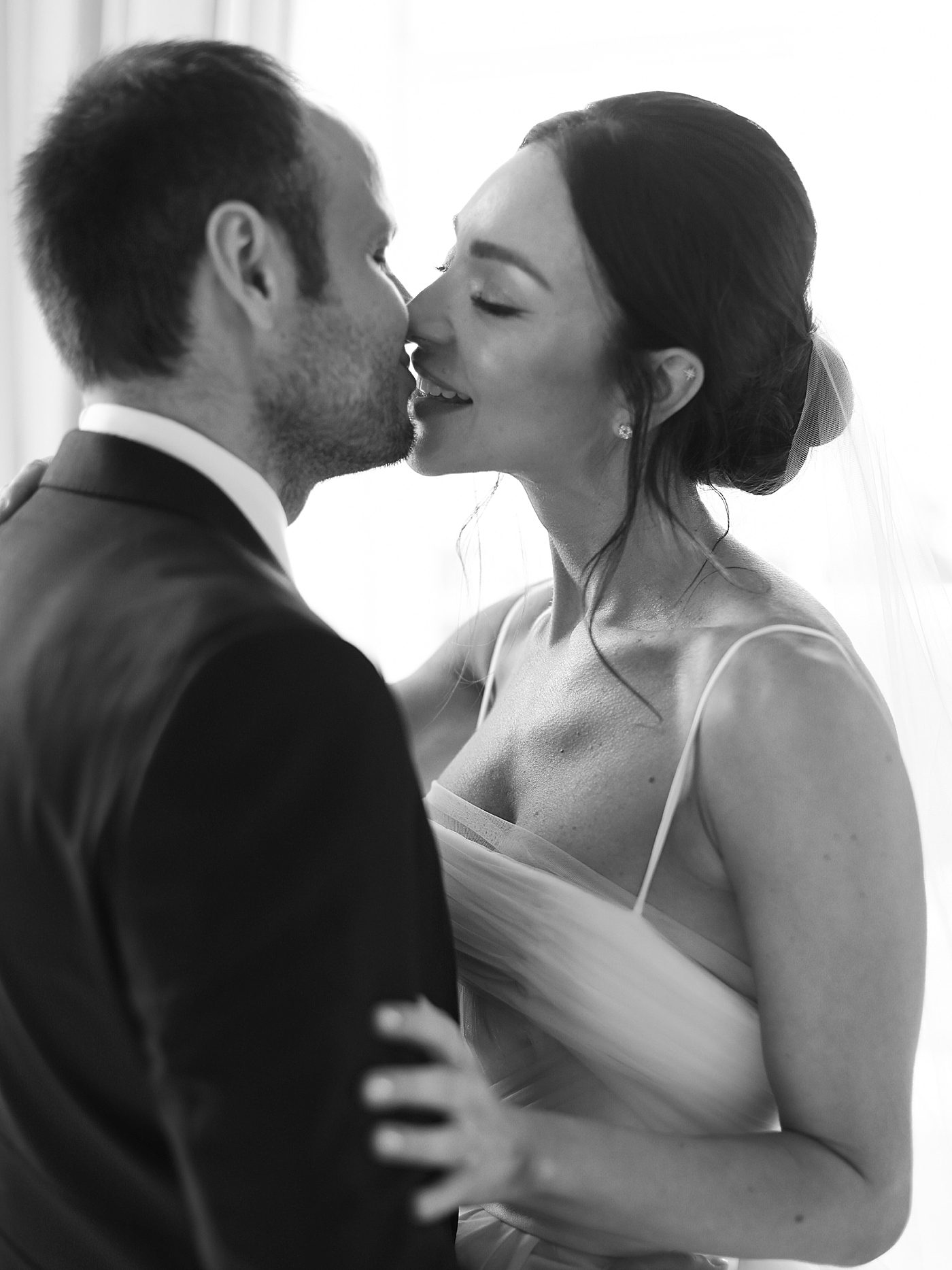 Black and white image of bride and groom kissing | Photo by Diane Sotero Photography