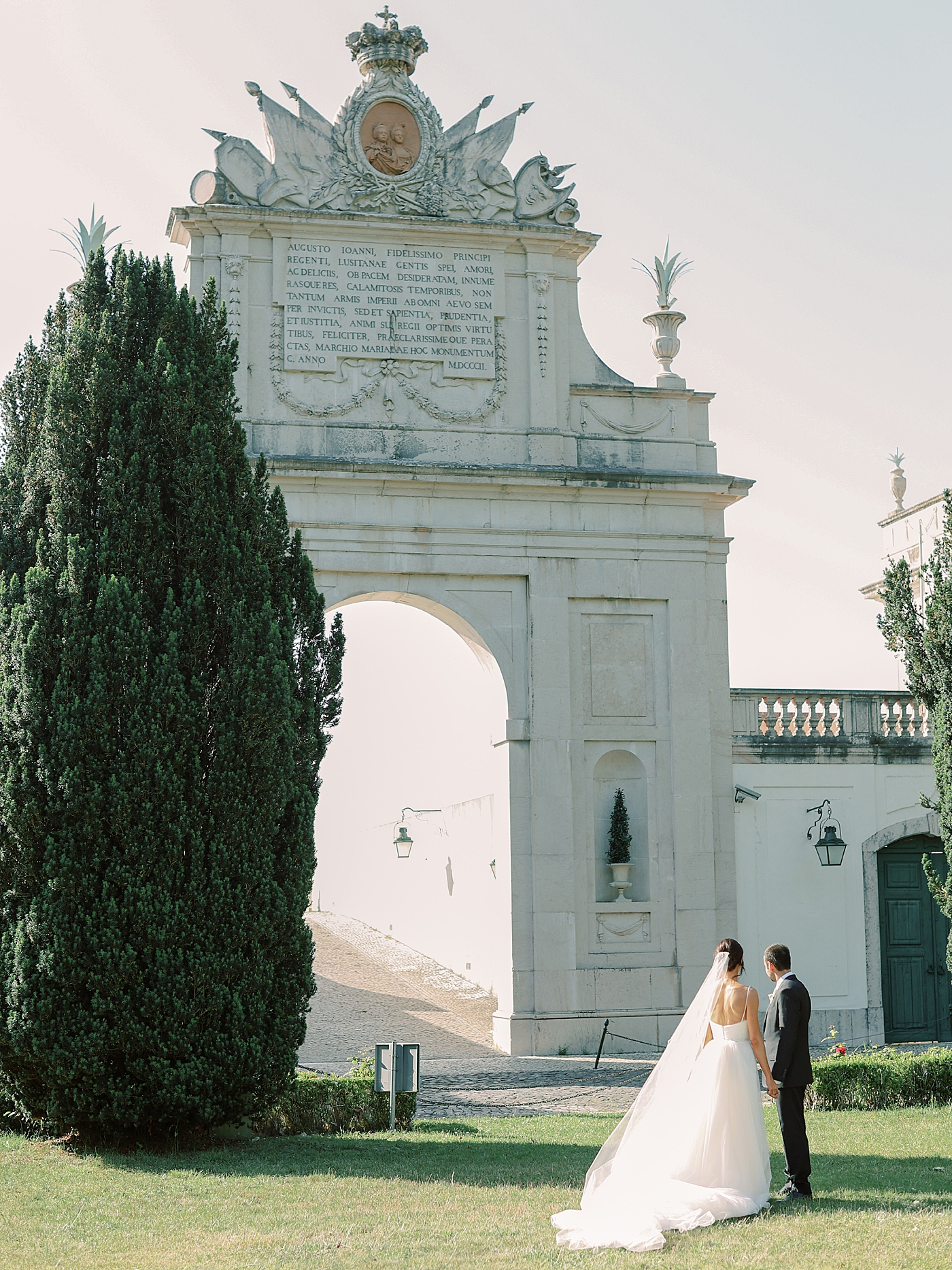 Bride and groom holding hands looking through a monument | Photo by Diane Sotero Photography