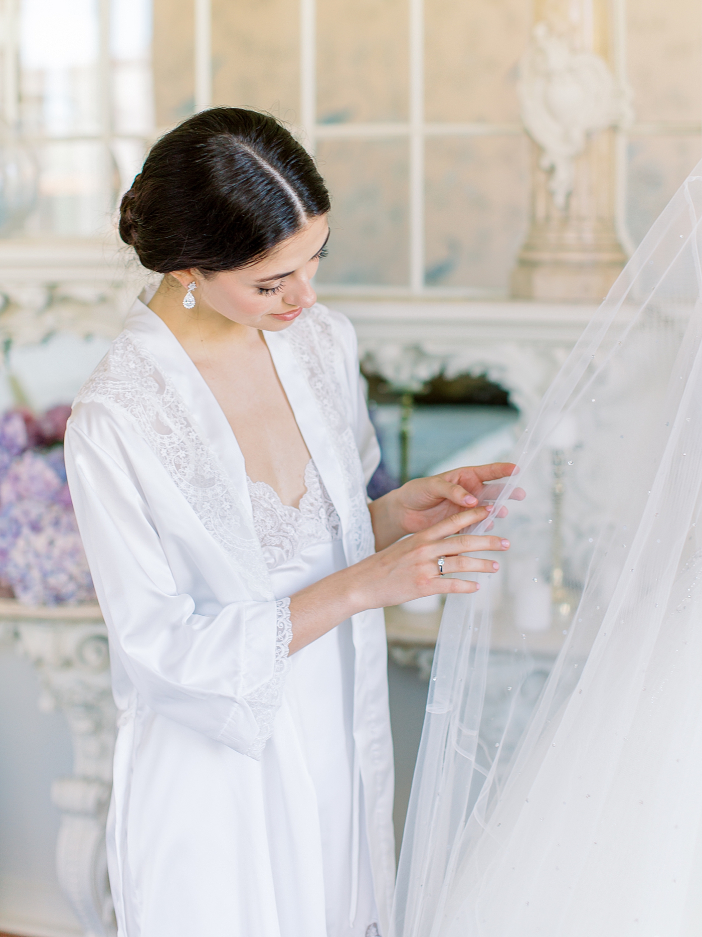Bride admiring her veil on a mannequin | Image by Diane Sotero 