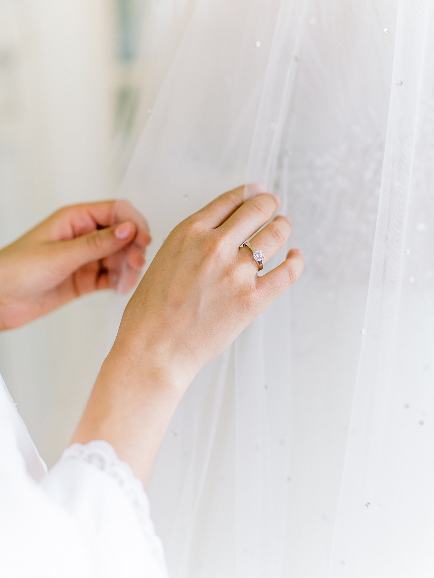 Detail of bride's hands adjusting her veil | Image by Diane Sotero 